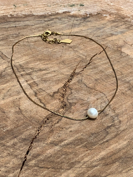 Freshwater pearl floating on a vintage brass box snake chain