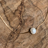 Freshwater pearl floating on a vintage brass box snake chain